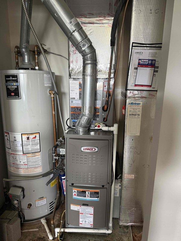 Completed full installation of Lennox air conditioning system and evaporator coil at residential property. New outdoor condensing unit was positioned on concrete pad alongside exterior wall with proper clearances maintained, and indoor evaporator coil was installed in conjunction with existing Lennox furnace in utility room. All refrigerant lines, electrical connections, condensate drainage, and ductwork transitions were properly completed, system was charged to manufacturer specifications, and unit was tested to verify proper operation and cooling performance.