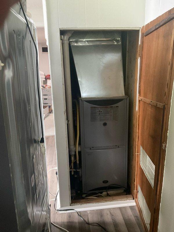 Evaluated residential property for central air conditioning installation where existing furnace and ductwork are present but no AC system currently installed. Assessed utility closet space containing white furnace unit with metal plenum, confirmed adequate return air ventilation, and verified existing duct infrastructure appears suitable for AC integration.