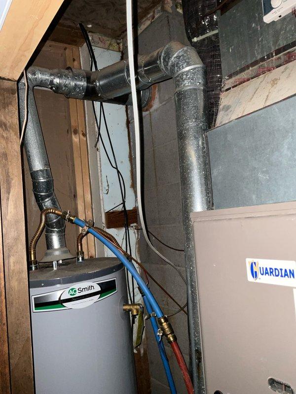 Conducted HVAC system evaluation for equipment replacement in residential basement utility area. The existing air conditioning unit from 2005 had been non-operational for approximately one year and was already removed from the property to allow for construction of properly sized equipment pad. Assessed current furnace installation and existing ductwork configuration, including supply and return plenum connections. Documented mechanical room layout with water heater, Guardian system components, and existing ventilation infrastructure. Measured available space and evaluated electrical service capacity for new equipment installation. Prepared two replacement options: complete HVAC system replacement including both furnace and air conditioning unit, and air conditioning unit replacement only, with proper equipment sizing calculations to address concerns about previous unit capacity.