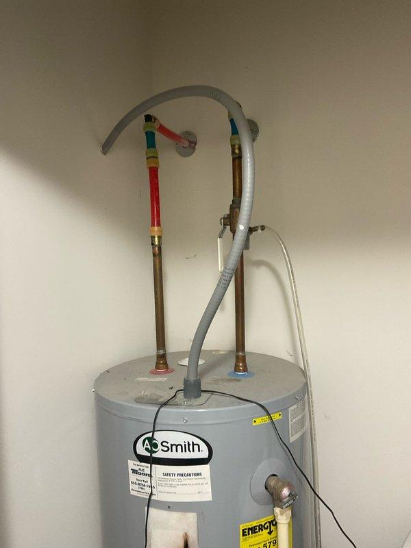 Completed estimate for water heater replacement. Documented existing A.O. Smith unit showing visible rust staining and signs of previous moisture issues, indicating need for replacement with proper assessment of current plumbing connections including copper supply lines and existing valve configuration.
