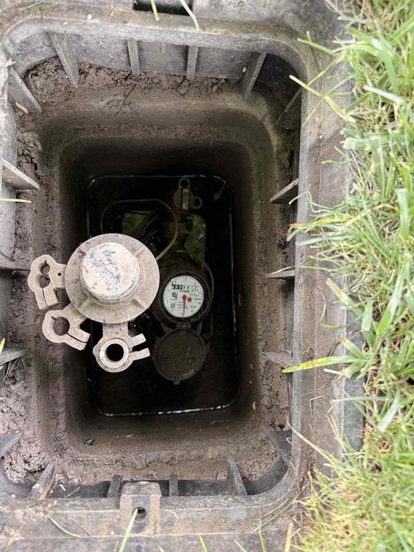 Responded to a water leak in the lawn area where the source was initially unknown to the property owner. Upon arrival, located and accessed the underground utility meter pit to investigate the water distribution system. Inspected the water meter assembly and main shutoff valve, which displayed significant corrosion and aging on the metallic components. Identified the leak source within the meter pit area. Also examined the North Star water softener system as part of the comprehensive evaluation, noting operational status and observing mineral buildup within the brine tank and float assembly. Successfully diagnosed the leak location and provided on-site assessment of the plumbing infrastructure condition.