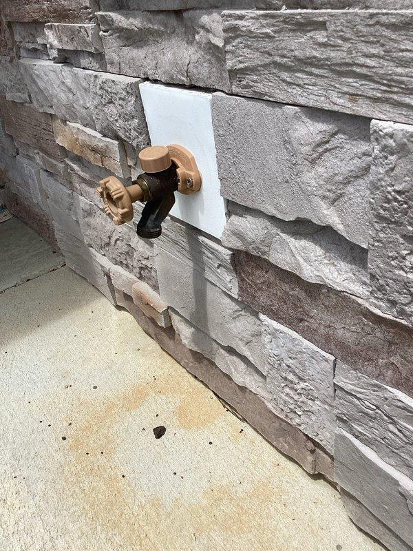 Completed annual plumbing inspection of residential property. Inspected interior drainage system including PVC piping and connections in utility area, verifying proper mounting and support. Examined exterior hose bib installation on stone veneer wall, confirming proper operation and secure mounting. All plumbing fixtures and visible piping found to be in satisfactory condition with no leaks or deficiencies noted. Documentation photos captured for maintenance records.