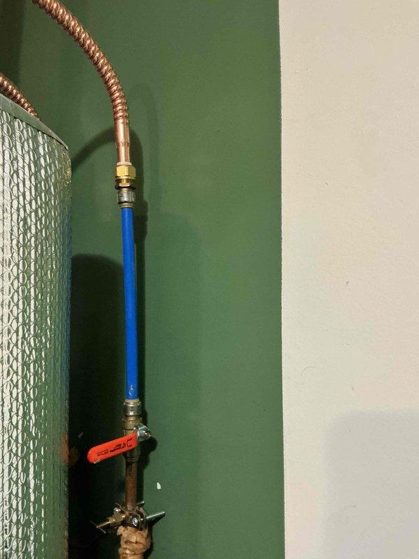 Installed a complete whole-house water filtration system on the main water supply line, including mounting the filter housing with clear cartridge chamber to the wall using secure brackets, connecting blue PVC supply piping, and integrating a brass shut-off valve with lever handle for system isolation and maintenance access. All connections were properly fitted and tested to ensure leak-free operation and optimal water flow throughout the residence.