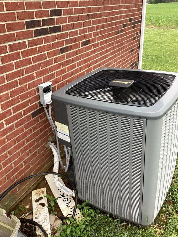 Completed heating maintenance on CCHP system. Performed system diagnostics using refrigerant manifold gauge, recording pressures of 122.3 PSIG suction and 218.3 PSIG discharge with corresponding temperature readings. Inspected outdoor condensing unit positioned on concrete pad against exterior brick wall, noting PVC condensate lines properly routed. Customer's plan had expired but service was owed under previous agreement. Standard 20x20x4 filter replacement not included in this maintenance visit.