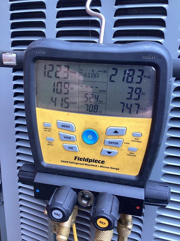 Completed heating maintenance on CCHP system. Performed system diagnostics using refrigerant manifold gauge, recording pressures of 122.3 PSIG suction and 218.3 PSIG discharge with corresponding temperature readings. Inspected outdoor condensing unit positioned on concrete pad against exterior brick wall, noting PVC condensate lines properly routed. Customer's plan had expired but service was owed under previous agreement. Standard 20x20x4 filter replacement not included in this maintenance visit.