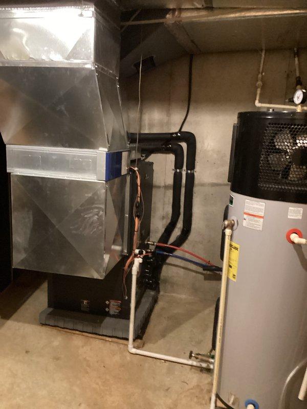 Performed routine cooling maintenance on residential HVAC system. Inspected air handler unit, blower motor assembly, and refrigerant lines for proper operation. Documented equipment condition through photographs showing furnace, water heater, and mechanical components in basement installation. System components appeared operational with normal dust accumulation on blower assembly. Recommended providing membership pamphlet to customer and noted air filter status requires verification for future service records.
