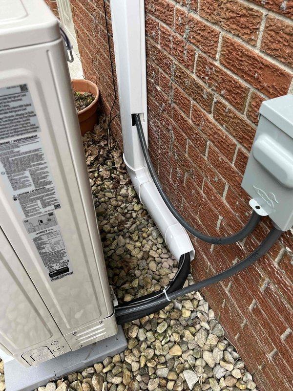 Completed installation of Lennox ductless mini-split system in residential property. Mounted indoor evaporator unit on interior wall beneath vaulted ceiling with exposed beam architecture, utilizing wooden backing board for secure attachment. Installed outdoor condenser unit on pad against exterior brick wall, established refrigerant line set and electrical connections via PVC conduit with proper mounting brackets, and verified system operation upon startup.