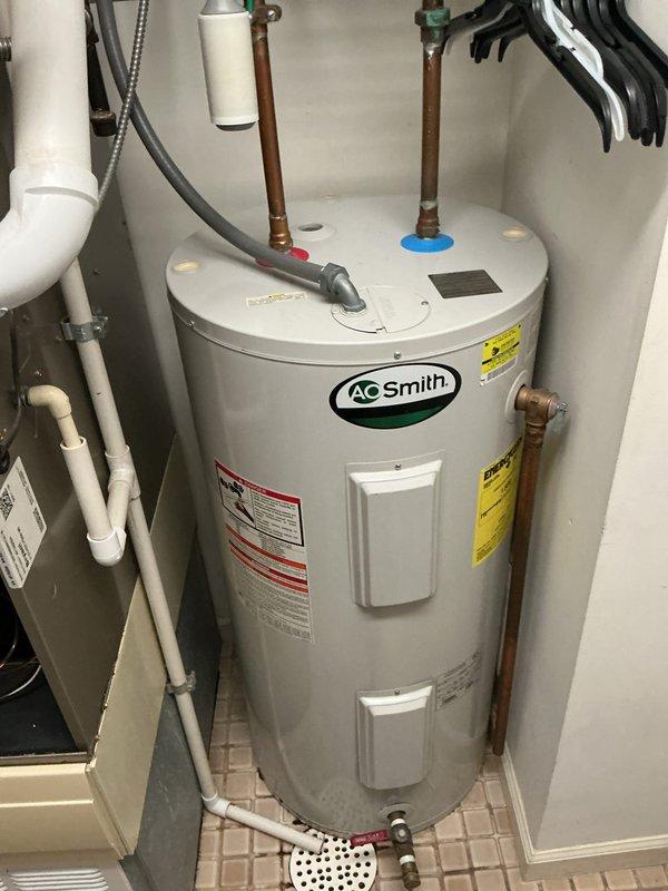 Performed comprehensive cleaning and inspection of HVAC system. Verified thermostat operation showing 71°F setpoint with system in cooling mode and auto fan configuration. Inspected water heater and associated plumbing connections, confirming proper installation of safety drain pan and secure pipe fittings with appropriate caps in place.