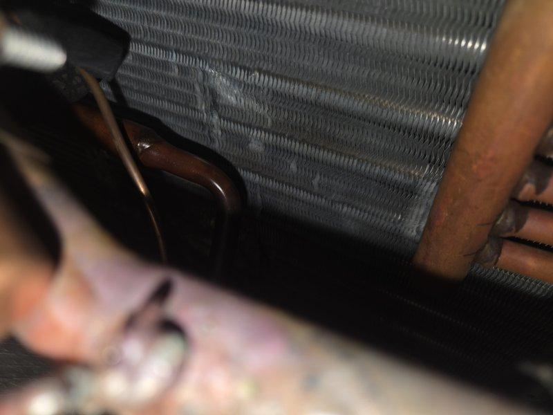 Responded to no cooling complaint on system with recently replaced TXV. Upon arrival, inspected evaporator coil and refrigerant lines. Found significant debris accumulation and contamination between coil fins, restricting airflow and reducing heat transfer efficiency. Noted oxidation on copper refrigerant lines consistent with system age. Documented coil condition with photos showing dirt buildup and discoloration throughout fin assembly. System requires thorough coil cleaning to restore proper airflow and cooling capacity.
