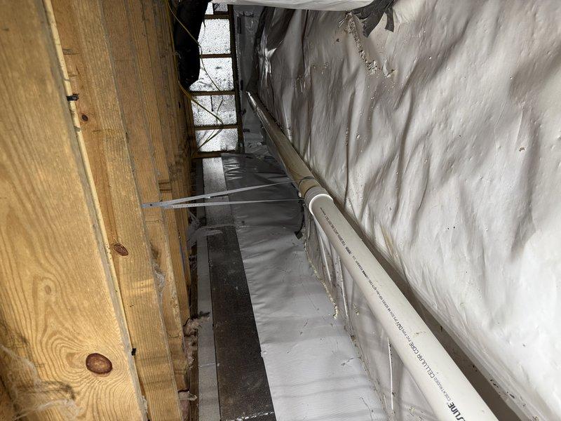 Completed repipe of bellied section in drain line located in crawl space. Removed deteriorated portion of drainage piping that had developed a sag, causing improper flow and potential backup issues. Installed new white PVC drainage pipe with proper slope and support to ensure adequate drainage performance. New piping was secured to floor joists using appropriate hangers and strapping to prevent future settling or movement. All connections were properly solvent-welded per code requirements. Verified proper flow and drainage upon completion. Work area was accessed through crawl space with existing HVAC ductwork and insulation in place.