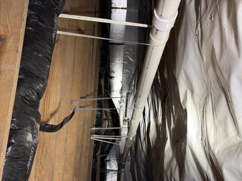 Completed repipe of bellied section in drain line located in crawl space. Removed deteriorated portion of drainage piping that had developed a sag, causing improper flow and potential backup issues. Installed new white PVC drainage pipe with proper slope and support to ensure adequate drainage performance. New piping was secured to floor joists using appropriate hangers and strapping to prevent future settling or movement. All connections were properly solvent-welded per code requirements. Verified proper flow and drainage upon completion. Work area was accessed through crawl space with existing HVAC ductwork and insulation in place.