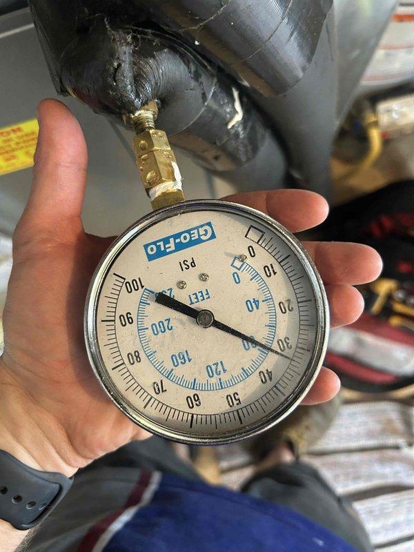 Responded to geothermal system failure with yellow and red indicator lights flashing, specifically high pressure alarm activated after customer returned from vacation and attempted system reset. Performed diagnostic pressure testing on refrigerant circuit using calibrated gauges, documenting readings at multiple test points to identify high pressure condition. System requires valve caps replacement as previously noted; recommend addressing during scheduled maintenance appointment.