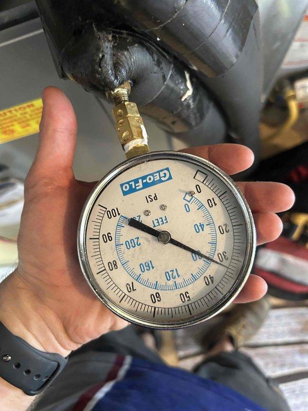 Responded to geothermal system failure with yellow and red indicator lights flashing, specifically high pressure alarm activated after customer returned from vacation and attempted system reset. Performed diagnostic pressure testing on refrigerant circuit using calibrated gauges, documenting readings at multiple test points to identify high pressure condition. System requires valve caps replacement as previously noted; recommend addressing during scheduled maintenance appointment.