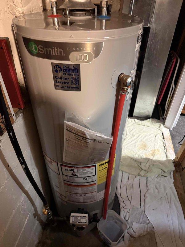 Responded to emergency call for hot water leak from recently installed temperature and pressure relief valve on A.O. Smith Signature 100 water heater. Upon arrival, found T&P relief valve had discharged, causing water intrusion into basement area. Inspected water heater installation, including copper supply piping, inlet/outlet connections, expansion tank with brass fittings and corrugated flexible connector, and T&P relief valve discharge pipe. Assessed system pressure and temperature conditions to determine cause of valve activation. Replaced faulty temperature and pressure relief valve and verified proper operation of expansion tank to prevent excessive system pressure buildup. Tested all connections for leaks, confirmed proper water flow restoration, and verified system returned to normal operating parameters with no further discharge occurring.