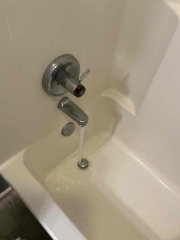 Completed prepaid plumbing inspection of residential property, coordinating timing with HVAC service between 10-12. Inspected and documented water supply line installation in utility closet, including blue PVC piping with orange ball valve shut-off and brass compression fittings. Examined bathroom plumbing fixtures including bathtub with chrome single-handle faucet assembly, tub spout, and drain. All components photographed for record. No immediate repairs required at time of inspection.