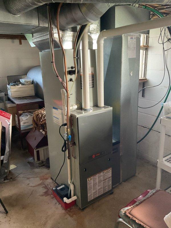 Performed comfort consultation and full system replacement estimate for 16-year-old Trane heat pump with propane furnace backup. Existing system diagnosed with failed thermal expansion valve (TXV), prompting homeowner's request for complete replacement options. Documented outdoor condensing unit and indoor air handler/furnace configuration, assessed current installation including refrigerant line routing, ductwork connections, electrical service, and equipment placement in basement mechanical room.