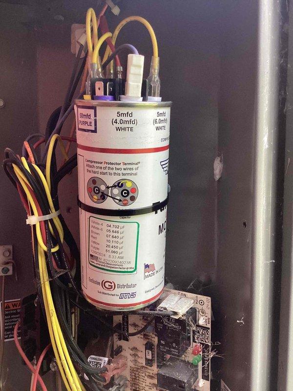 Responded to no-cooling complaint on Lennox residential air conditioning system. Upon arrival, found outdoor unit condenser fan motor inoperative; manually started fan motor but system still failed to produce cooling. Inspected electrical components and capacitor in control panel, documented existing dual-run capacitor configuration and wiring connections for diagnostic purposes.