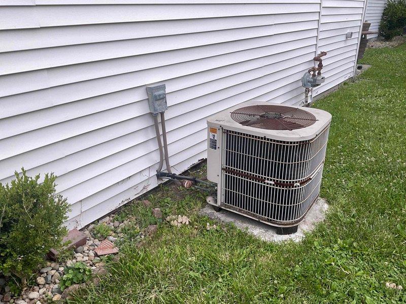 Conducted comprehensive evaluation of existing HVAC system for full replacement estimate. Unit assessed as 24+ years old with significant deterioration including rusted components, refrigerant leaks, and end-of-service-life condition. Documented equipment specifications and site conditions with photographic evidence showing exterior condensing unit on concrete pad with weathered housing, corroded fan grille, and compromised refrigerant lines. Provided complete system replacement recommendations and financing options to address failed equipment.