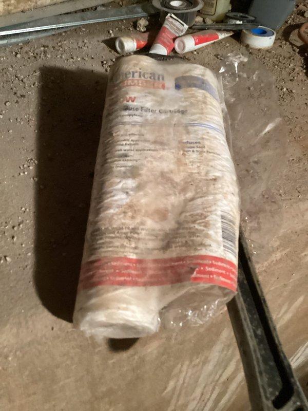Responded to complaint of weak water pressure throughout home and trickling shower flow. Upon inspection, discovered severely corroded and deteriorated sediment filter housing in main water line system. The existing filter canister exhibited extensive rust buildup and scaling, causing significant flow restriction to entire plumbing system. Replaced failed filter housing and installed new American Plumber sediment filter cartridge. Verified proper connections to existing PVC piping network and water treatment system. Tested water pressure at multiple fixtures following replacement and confirmed restoration of adequate flow to shower and throughout residence.