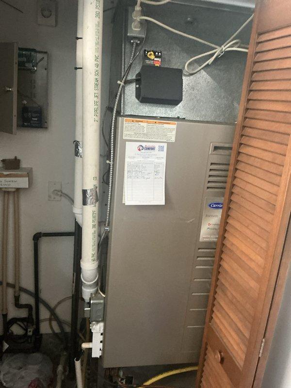 Completed monthly basic cooling maintenance visit on residential HVAC system. Performed standard inspection of Carrier air handler unit and associated components, verified proper operation of cooling equipment, and documented system condition with photographs showing water heater and furnace installations in mechanical room.