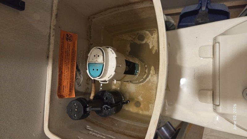 Completed monthly prepaid plumbing inspection of residential property. Inspected toilet tank assembly, noting significant mineral deposits and water staining on interior surfaces; flush valve mechanism and float valve assembly operating properly despite visible age-related buildup. Examined water heater installation, verifying proper drain valve function and connection integrity; all components functioning within normal parameters with no active leaks detected.