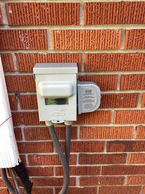 Attempted installation of surge protector at outdoor HVAC disconnect location but encountered seized screws on existing disconnect box that prevented access to electrical connections. Unable to remove disconnect cover due to corroded or overtightened fasteners. Recommended and sold replacement disconnect box to complete surge protector installation, with return visit scheduled to install new disconnect and finish surge protector hookup.