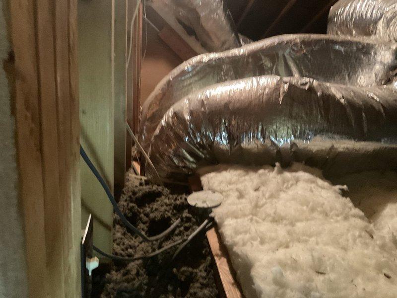 Conducted comprehensive attic inspection to assess ductwork system and provide duct cleaning estimate. Evaluated extensive flexible ductwork installation throughout attic space, including multiple runs of metallic flex ducts in both silver and dark-colored materials. Documented current condition of HVAC distribution system, noting ductwork routing, insulation coverage, and accessibility for cleaning procedures. Photographed attic space showing fiberglass insulation coverage and ductwork configuration to support estimate preparation for complete duct cleaning service.