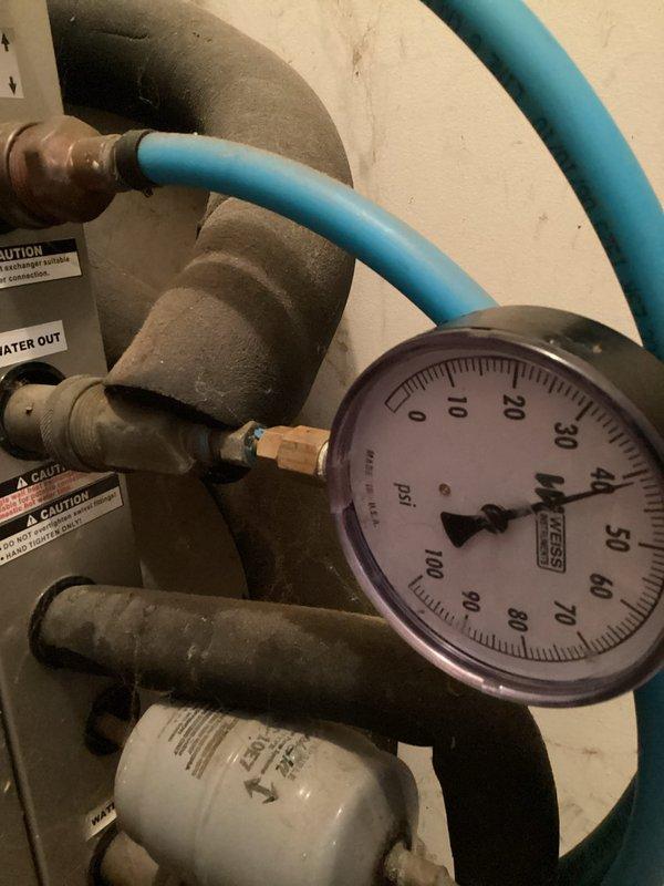 Performed diagnostic evaluation on geothermal heat pump system experiencing inadequate heating capacity during winter months, resulting in frequent auxiliary electric resistance heat operation. Inspected ground loop pressure gauge readings, piping connections, and turquoise-insulated ground loop supply/return lines. Reviewed thermostat programming and system operation settings on digital control interface. Discussed customer request for converting auxiliary heating system from electric resistance to natural gas backup heat and provided consultation on conversion requirements and equipment options for future consideration.