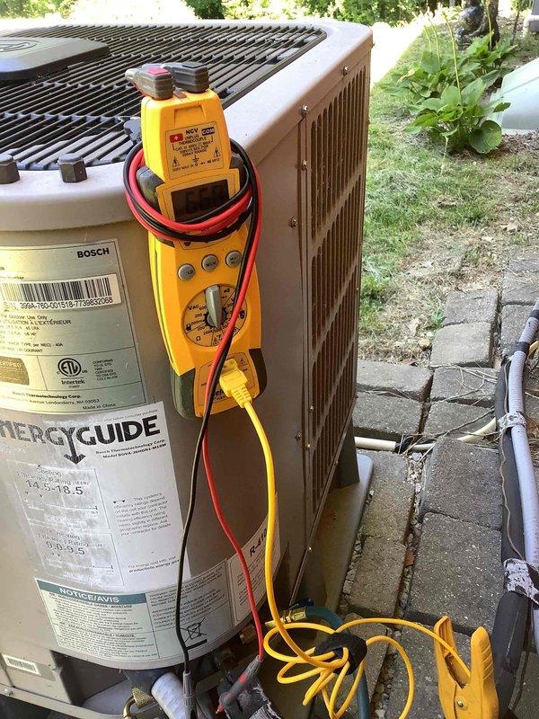 Responded to water leak complaint at basement indoor unit. Upon inspection, found evidence of condensate drainage issue with significant moisture accumulation on concrete floor showing efflorescence and mineral deposits. Performed diagnostic testing on outdoor Bosch condenser unit using multimeter to verify system operation and identify root cause of water leak. Documented moisture damage and system conditions for further evaluation and corrective action.