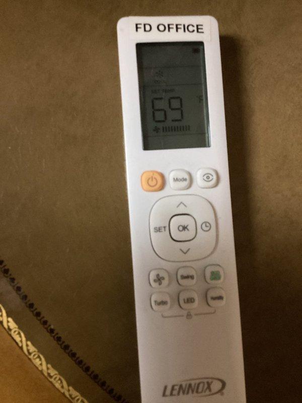 Returned to property to continue refrigerant leak search on Lennox system. Used psychrometer at supply diffuser to measure air conditions and verify system performance. Tested airflow and temperature readings at office zone controlled by Lennox remote thermostat set to 69°F to assess cooling capacity during leak detection process.