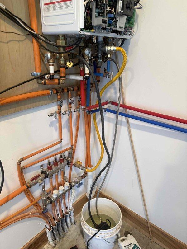 Performed comprehensive descaling flush on TF 99 tankless water heater to address lime buildup affecting unit performance. Installed new water softener system on cold water supply line to prevent future mineral accumulation and extend equipment lifespan.