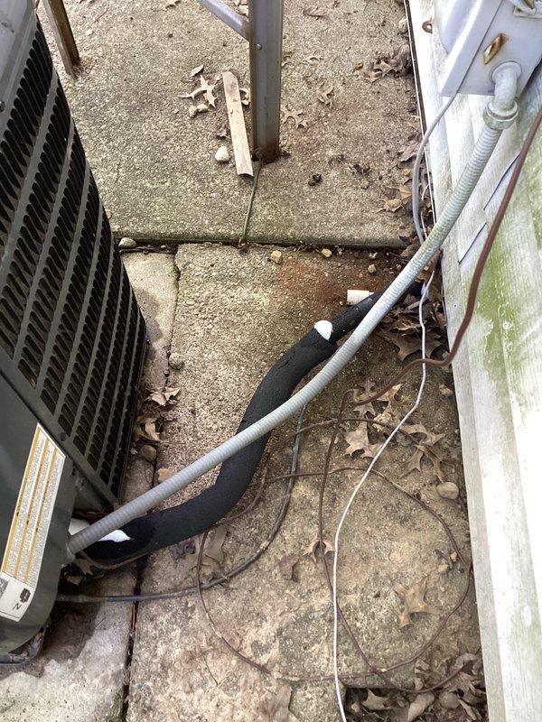 Responded to cooling complaint on commercial air conditioning system. Upon arrival, inspected outdoor condensing unit and found damaged refrigerant line insulation exposing copper piping to elements. Checked electrical disconnect and fuses, confirming power supply to unit was intact with both fuses operational. System was running but unable to maintain adequate cooling capacity, consistent with previous service history from earlier visits. Documented equipment condition including weathered concrete pad, aged HVAC components, and compromised line set insulation requiring attention to prevent further efficiency loss and potential refrigerant line damage.