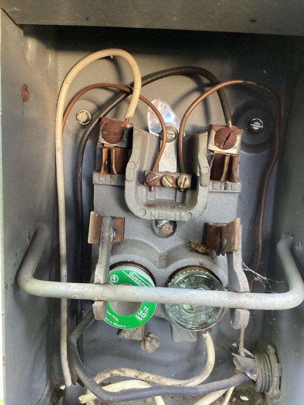 Responded to cooling complaint on commercial air conditioning system. Upon arrival, inspected outdoor condensing unit and found damaged refrigerant line insulation exposing copper piping to elements. Checked electrical disconnect and fuses, confirming power supply to unit was intact with both fuses operational. System was running but unable to maintain adequate cooling capacity, consistent with previous service history from earlier visits. Documented equipment condition including weathered concrete pad, aged HVAC components, and compromised line set insulation requiring attention to prevent further efficiency loss and potential refrigerant line damage.