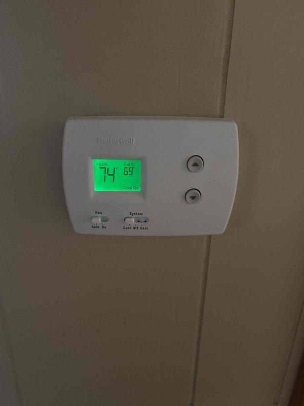 Responded to service call for water leakage from HVAC unit. Inspected outdoor condenser unit and found condensate drainage issue. Cleared condensate drain line obstruction, verified proper drainage flow, and tested system operation. Confirmed thermostat functioning correctly with unit cooling properly to setpoint of 69°F. System operating within normal parameters with no further leakage observed upon completion.