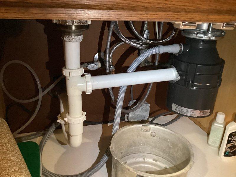 Responded to service call for multiple plumbing concerns including a leaking hydrant, kitchen sink leak, and downstairs bathtub drain plug replacement. Conducted thorough inspection of kitchen sink plumbing system, examining P-trap assembly, garbage disposal connections, supply lines, and drainage components for sources of leakage. Verified all slip-joint fittings and connections under sink were secure and functioning properly. Assessed bathtub drain plug issue that was previously identified but not addressed due to lack of replacement parts on hand during prior visit.