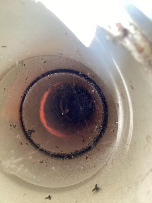 Responded to service call for overflowing toilet. Upon arrival, inspected toilet bowl and drain assembly, noting visible staining and debris accumulation around the interior surfaces and drain opening. Examined the flush mechanism and identified blockage causing overflow condition. Cleared obstruction from drain line and verified proper water flow and drainage. Tested flush cycle multiple times to ensure complete resolution of overflow issue. Toilet restored to normal operating condition with no further signs of backup or overflow.