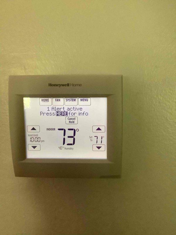 Completed monthly basic cooling maintenance visit on residential HVAC system. Inspected furnace unit with integrated cooling components, verified thermostat operation showing active alert notification with system holding at 73°F and set point of 71°F. Documented equipment condition including PVC venting configuration and lower filter housing, confirmed system operational status and proper thermostat communication.