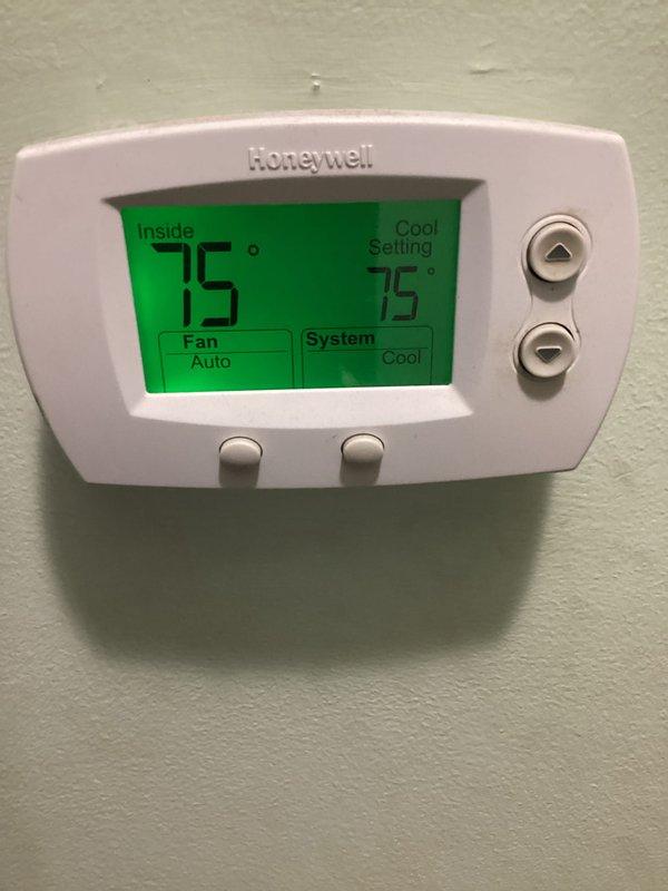 Completed routine HVAC maintenance on a residential cooling system, which included replacing the air filter as part of the basic preventive maintenance service. Inspected the outdoor condenser unit located beneath an elevated structure and verified the thermostat operation, confirming the system was cooling properly with the indoor temperature matching the setpoint of 75°F in cooling mode with the fan set to auto.