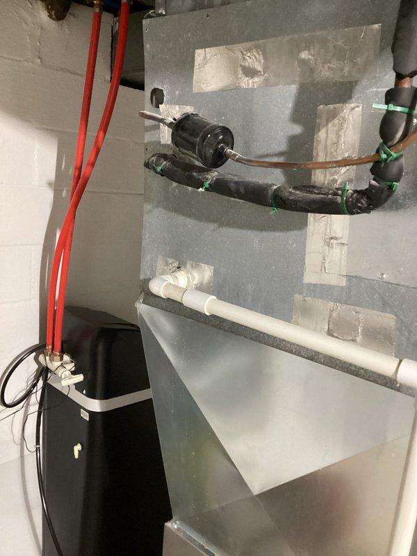 Responded to warranty call for HVAC system installed in December experiencing water dripping down the exterior of the unit. Upon inspection, identified condensate drainage issue affecting the indoor air handler. Evaluated condensate pump operation, PVC drain line routing, and connection points throughout the system. Documented existing installation including air handler positioning, condensate management components, drain line configuration with proper trap and slope, and electrical connections to condensate removal equipment. Verified all piping connections, mounting hardware, and drainage pathway from unit to discharge point. System components including black drain piping with compression fittings and white PVC discharge lines were photographed for warranty documentation purposes.