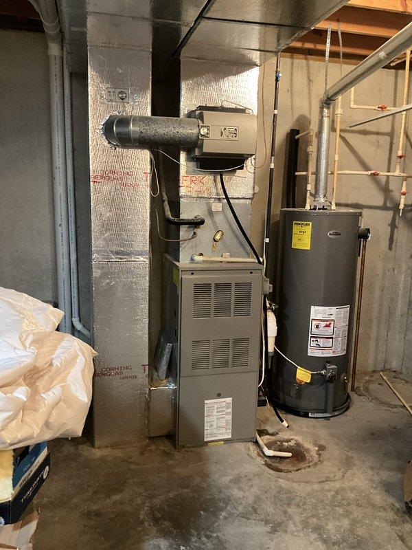 Conducted comprehensive assessment of 30-year-old HVAC system serving 2560 square foot residence with basement and first floor coverage. Evaluated existing 3-ton air conditioning condenser unit located on exterior gravel pad and 100,000 BTU natural gas furnace with 90%+ efficiency rating positioned in basement mechanical room. Documented current equipment configuration including ductwork routing, refrigerant line connections, electrical disconnect, and condensate drainage. Inspected furnace cabinet condition, heat exchanger accessibility, and ventilation duct connections with reflective insulation. Assessed outdoor condenser unit placement, airflow clearances, and electrical service components. Photographed existing installation showing equipment age, mounting configurations, and utility room layout with water heater proximity. Provided detailed replacement estimate for complete HVAC system upgrade to address non-operational air conditioning and aging equipment infrastructure requiring