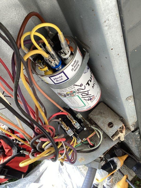 Responded to no cooling complaint on residential air conditioning system. Performed diagnostic inspection of air handler unit, accessed electrical compartment and inspected capacitor with multiple wire connections and terminals. Provided on-site assessment and repair recommendations to property owner for decision.