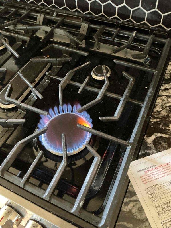Responded to gas odor complaint and coordinated with gas utility provider for leak detection. Gas company confirmed leak location above the shut-off valve requiring repair. Documented existing conditions including gas range with active burner operation and gas line configuration with shut-off valve and flexible connector at point of service.