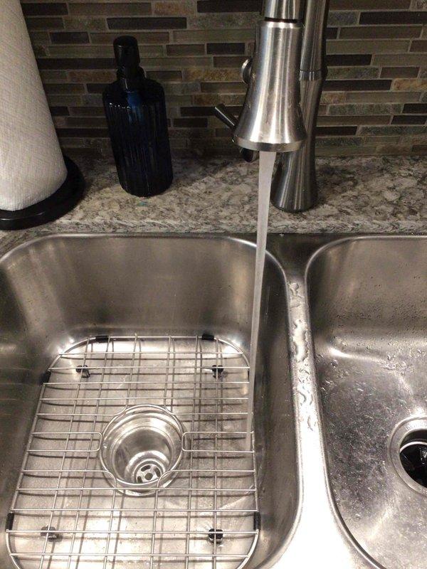Responded to kitchen sink drainage issue with suspected clog beyond the trap and garbage disposal problems. Inspected under-sink plumbing assembly including P-trap configuration and drain lines, assessed double-basin stainless steel sink with pull-down spray faucet, and evaluated drainage performance. Addressed blockage in drainage system to restore proper water flow and functionality to kitchen sink and disposal unit.