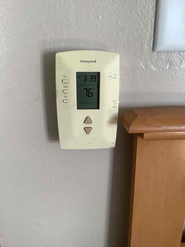 Responded to service call for air conditioning system not maintaining temperature at rental property. Upon inspection, discovered evaporator coil exhibiting severe corrosion with heavy oxidation throughout copper tubing, significantly reducing heat transfer efficiency and system cooling capacity. Thermostat reading 76°F indicated inadequate cooling performance. Documented condition of corroded coil assembly and discolored drain pan showing signs of age-related deterioration. Recommended evaporator coil replacement due to extent of corrosion compromising system operation.