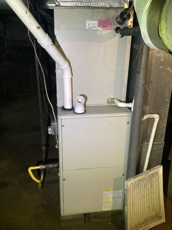 Responded to air conditioning repair request at residential property. Performed diagnostic inspection of complete HVAC system including Gibson brand outdoor condensing unit and indoor furnace assembly. Inspected outdoor condenser unit positioned on concrete pad, verified proper clearances from landscaping and structure, examined diamond-pattern protective grille for damage, and assessed overall unit condition. Checked indoor furnace installation in basement utility area, inspected gas line connections with shutoff valve, examined PVC condensate drain and vent piping, and evaluated flexible aluminum ductwork with fiberglass insulation. Noted heavily soiled air filter requiring replacement due to excessive dust accumulation affecting system airflow and efficiency. Verified all electrical connections, reviewed manufacturer specification labels, and documented equipment configuration. System operational upon completion of service call.
