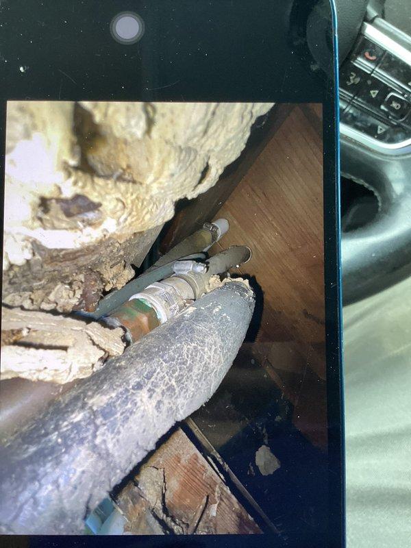 Responded to water leak investigation and utilized inspection camera to identify source of moisture intrusion. Located copper coupling with oxidation and deteriorated foam insulation on condensate drain line in confined space near exterior wall junction. Documented compromised pipe insulation and spray foam degradation contributing to water leakage issue.