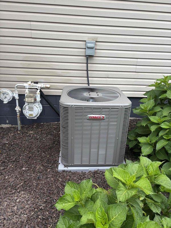 Completed installation of new Lennox air conditioning system and evaporator coil at residential property. Unit was positioned on concrete pad against exterior wall with proper clearances maintained, electrical disconnect and conduit installed per code, and all refrigerant lines properly connected and tested for optimal system performance.