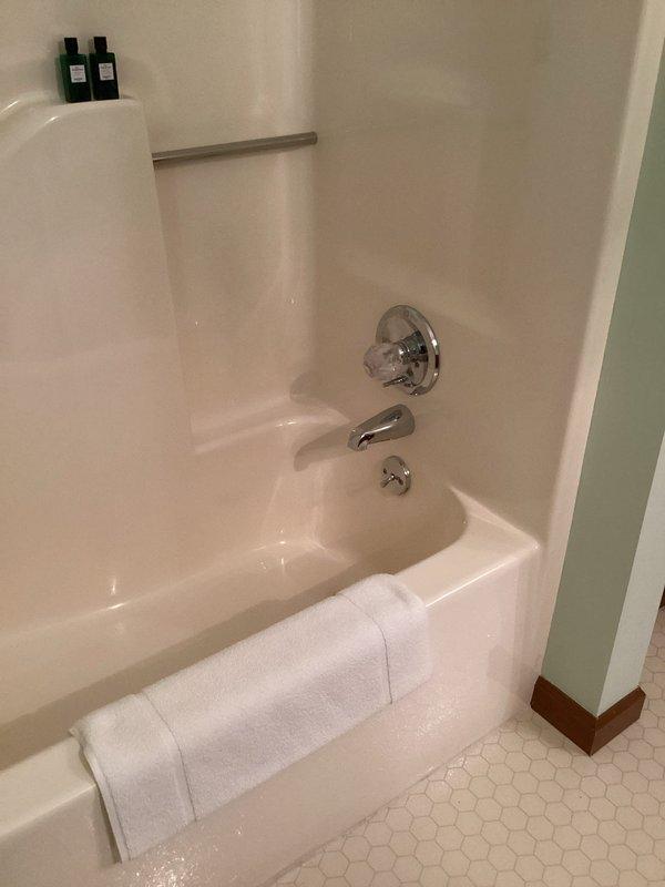Responded to report of water leaks in kitchen ceiling originating from bathroom above. Conducted thorough inspection of bathroom plumbing fixtures including toilet, bathtub, and shower assembly. Examined all visible supply lines, drain connections, and fixture mounting points for signs of active leaks or water damage. Inspected toilet tank components, fill valve, flush valve, and wax ring seal at floor connection. Evaluated bathtub and shower plumbing including faucet assembly, shower control valve, spout connection, and drain system for potential leak sources. No active leaks or moisture detected during visual inspection of accessible plumbing components. Documented bathroom condition with photographs showing all fixtures in proper working order with no visible water damage to surrounding walls, flooring, or fixture connections.