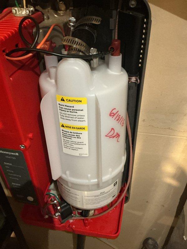 Completed installation of replacement humidifier canister and 20x20x4 air filter. The new canister was properly mounted to the existing bracket assembly with secure pipe connections and fittings, ensuring proper water flow to the humidification system.