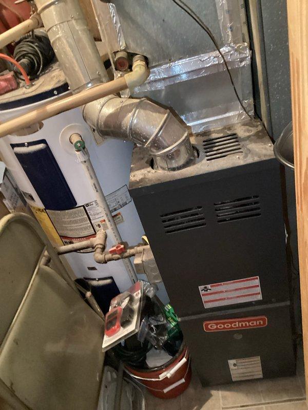 Responded to service call for non-functional air conditioning system at residential property. Upon arrival, performed comprehensive diagnostic inspection of existing Goodman HVAC system installation located in utility area. Evaluated furnace unit, refrigerant line connections, ductwork sealing, and thermostat operation. Inspected copper refrigerant lines and verified proper connection integrity at furnace interface. Examined aluminum foil tape applications on ductwork joints for air leakage. Assessed wall-mounted Hunter thermostat functionality, verifying proper wiring connections and system control settings including cooling, heating, and fan operation modes. System restored to normal operating condition following diagnostic evaluation and necessary adjustments.